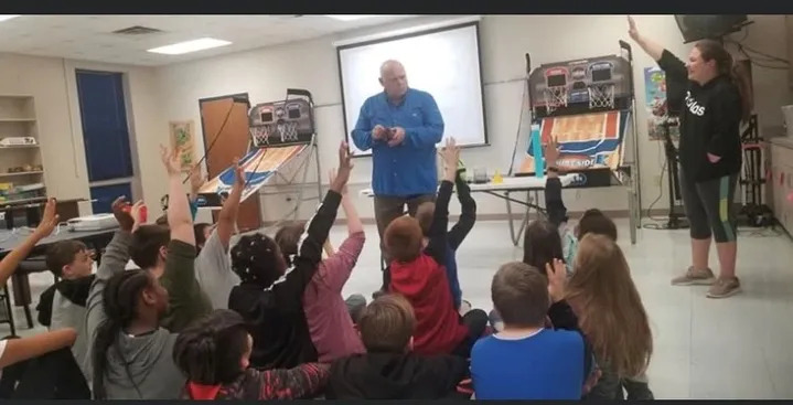 man in blue shirt in front of classroom 